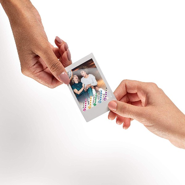 Dos manos sosteniendo una foto Polaroid de dos personas sonriendo.