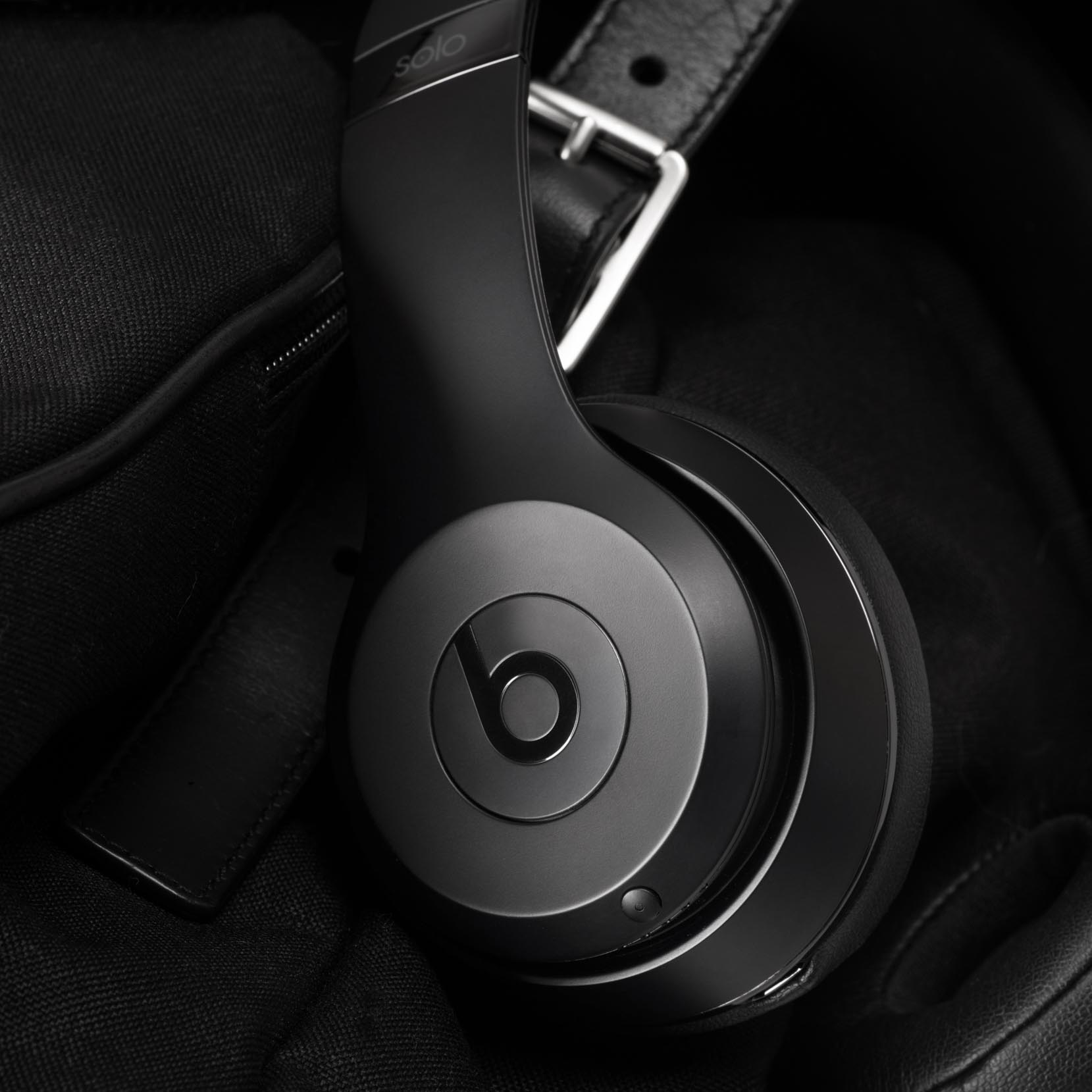 Schwarze Beats Solo Kopfhörer hängen über einer dunklen Tasche.