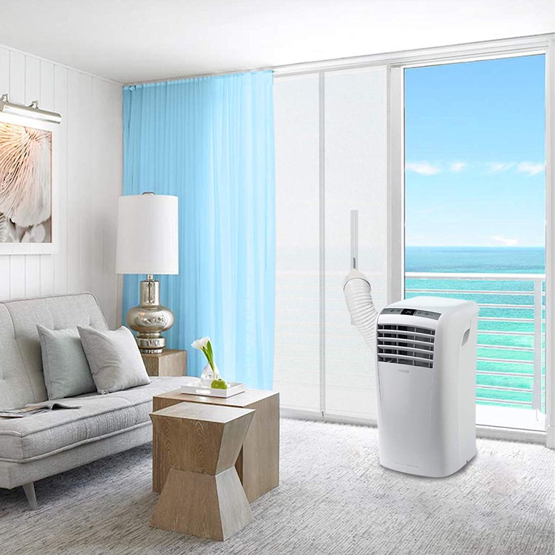 Klimaanlage in einem Raum. Blick auf das Meer durch ein Fenster und blaue Vorhänge.