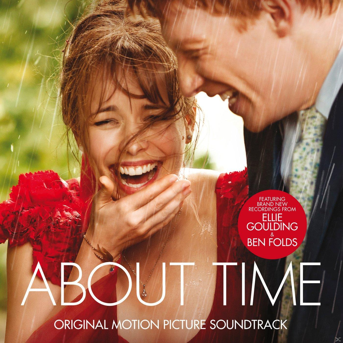 A 'About Time' album borítója. Egy pár nevet az esőben. Piros virágok az előtérben.