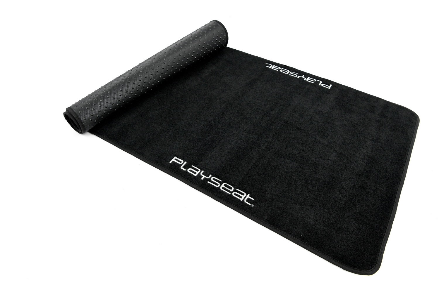 Alfombra Playseat negra enrollada, con 'PLAYSEAT' escrito en blanco. Fondo blanco.