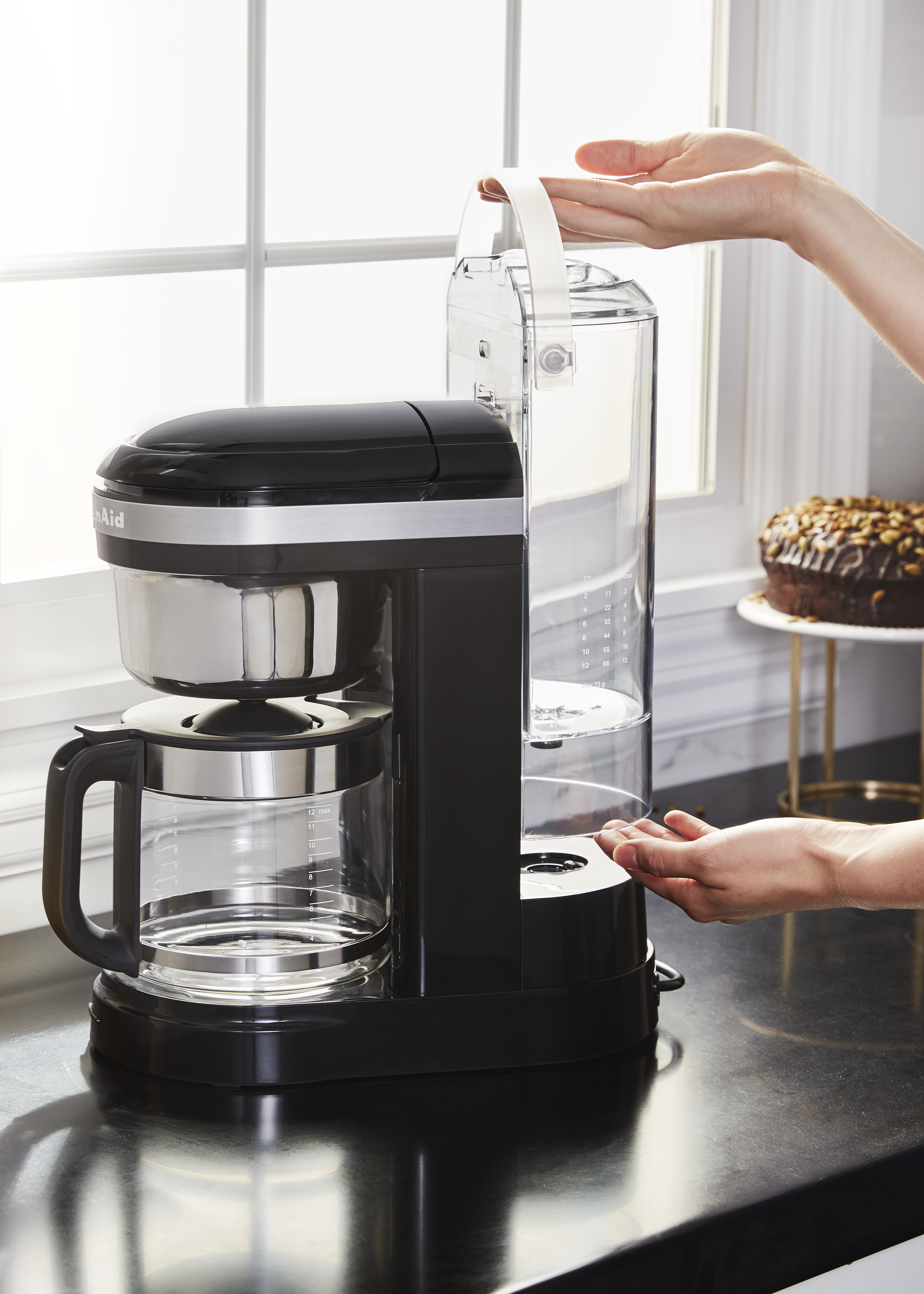 Schwarze und silberne KitchenAid Kaffeemaschine auf einer Arbeitsplatte.