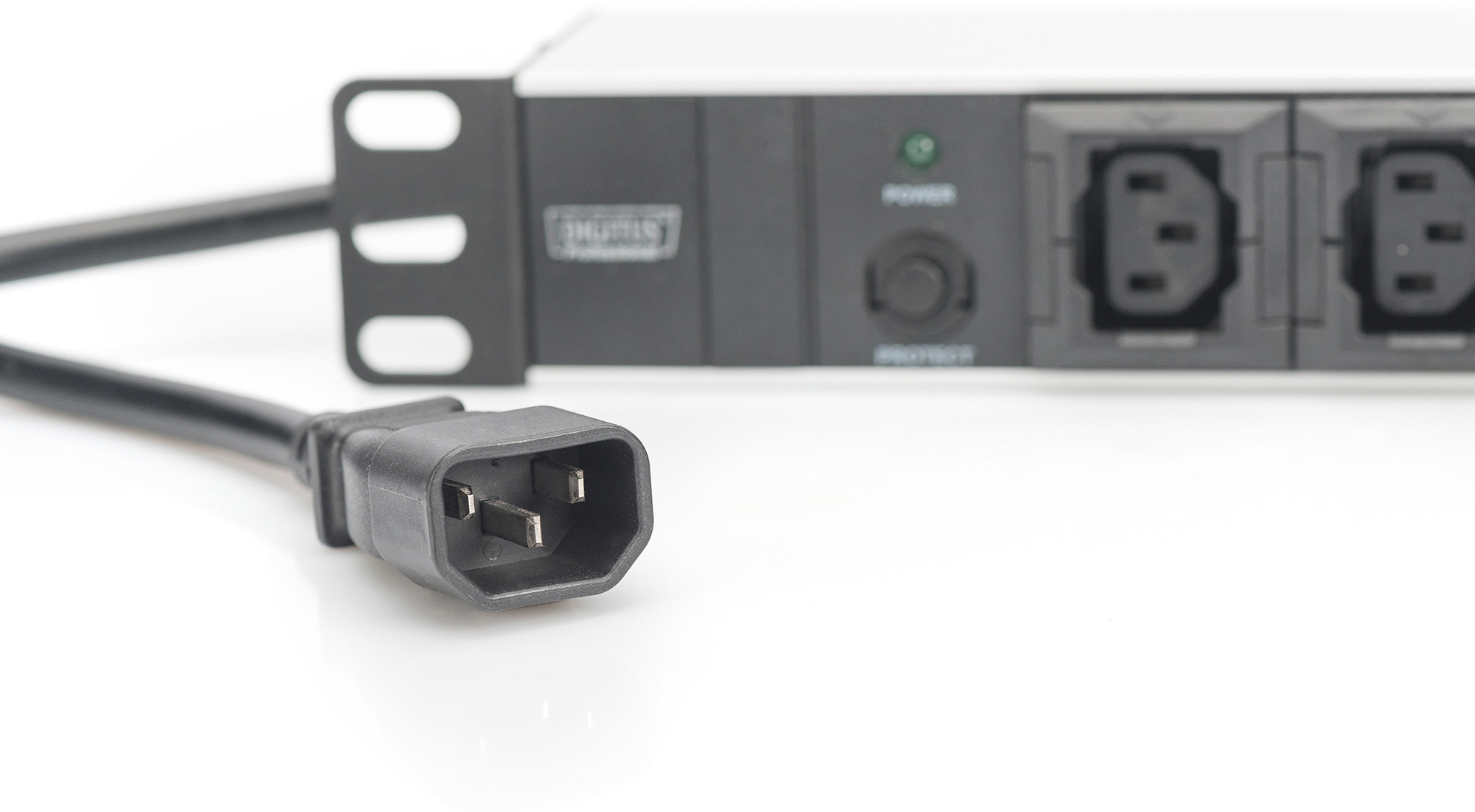 Ein schwarzer Stromkabelstecker ist im Vordergrund, im Hintergrund eine Rack-Stromverteilereinheit.