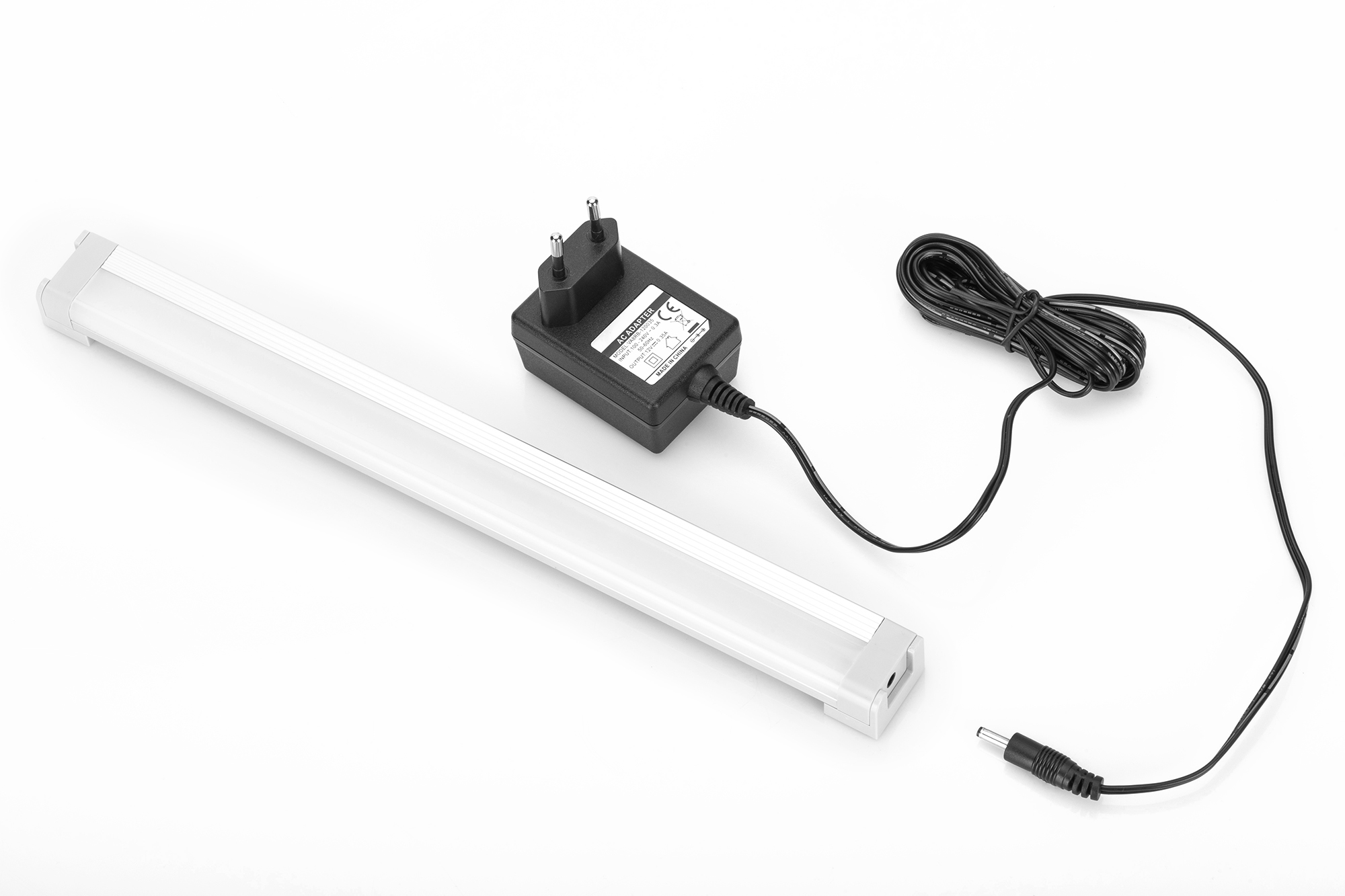 LED-Leuchtstreifen, Netzteil und Kabel auf weißem Hintergrund.