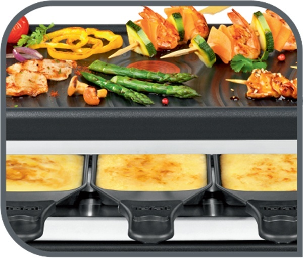 Raclette-Grill mit Essen, einschließlich Fleisch, Gemüse und Käse.