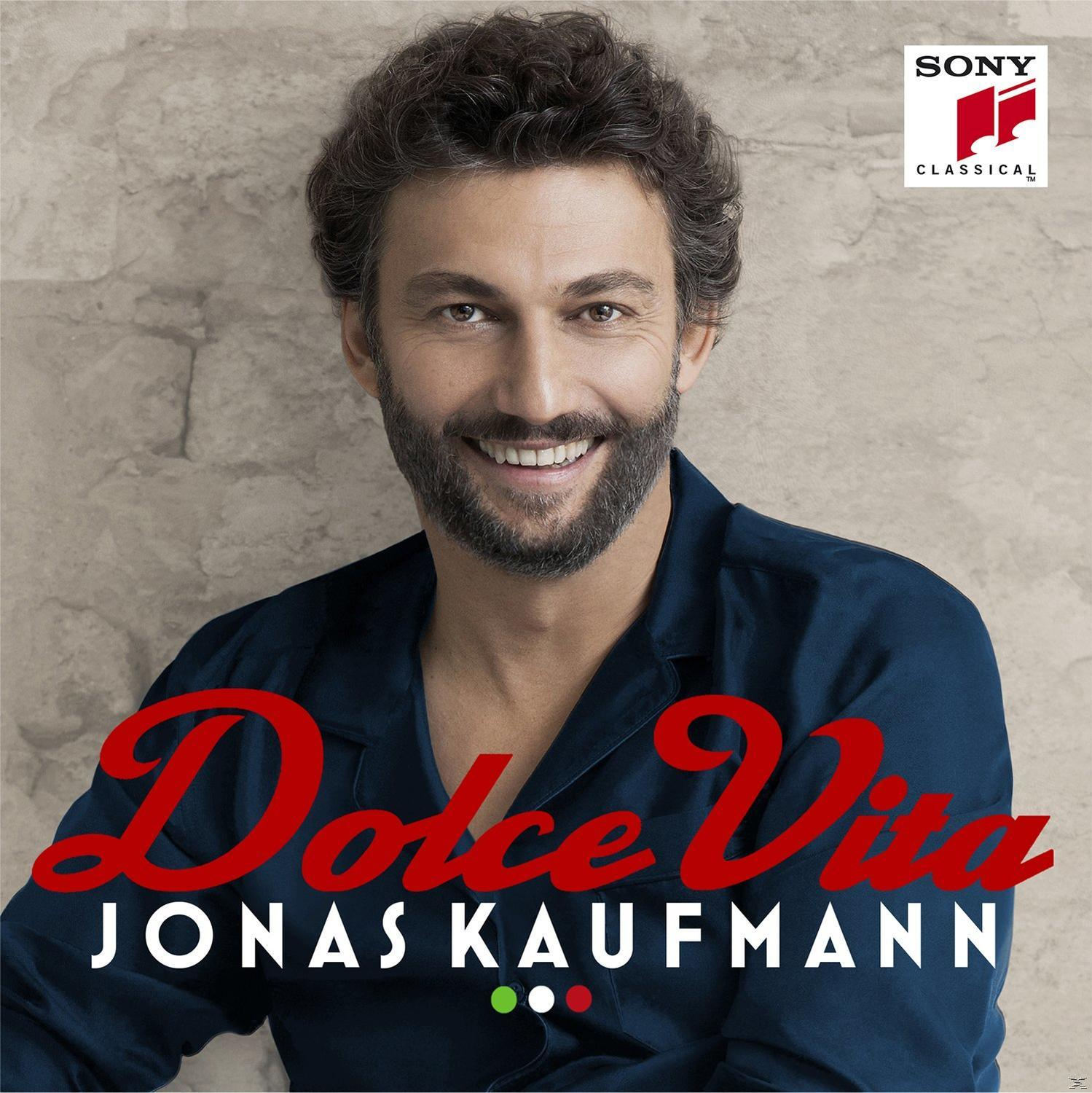 Jonas Kaufmann Albumcover. Er lächelt, trägt ein dunkelblaues Hemd und den Titel Dolce Vita.