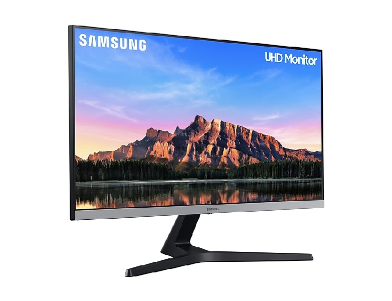 Un monitor Samsung UHD sobre un fondo blanco. La pantalla muestra un paisaje de montaña.