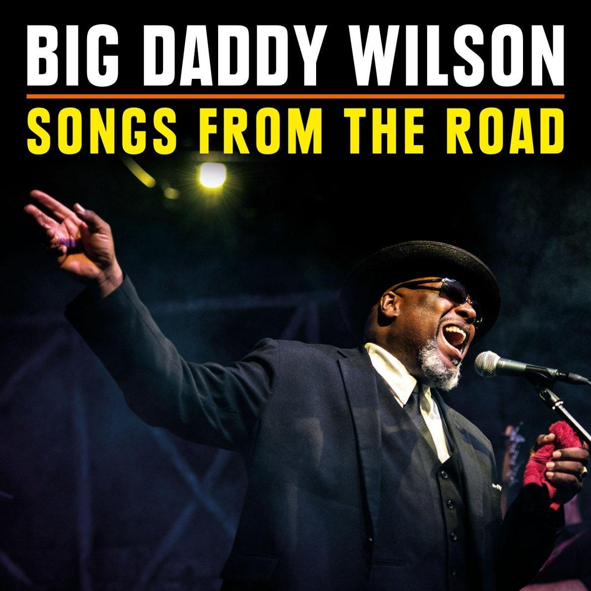 Albumcover mit einem schwarzen Mann, der in ein Mikrofon singt. Der Titel lautet "Big Daddy Wilson: Songs from the Road".