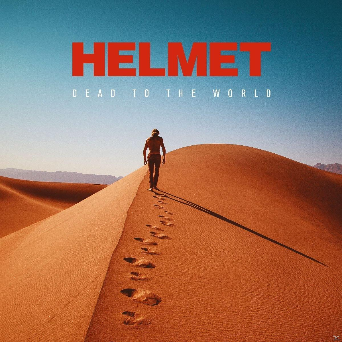 Mann geht auf einer Sanddüne, blauer Himmel. Titel: Helmet, Dead To The World. Fußabdrücke im Sand.