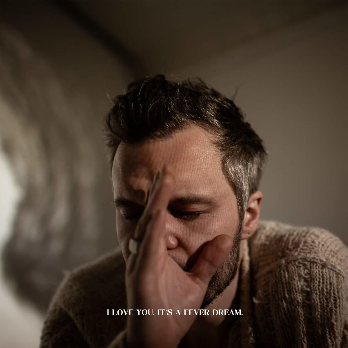 Albumcover mit einem Mann, der sein Gesicht berührt. Die Worte 'I LOVE YOU. IT'S A FEVER DREAM' stehen auf dem Bild.