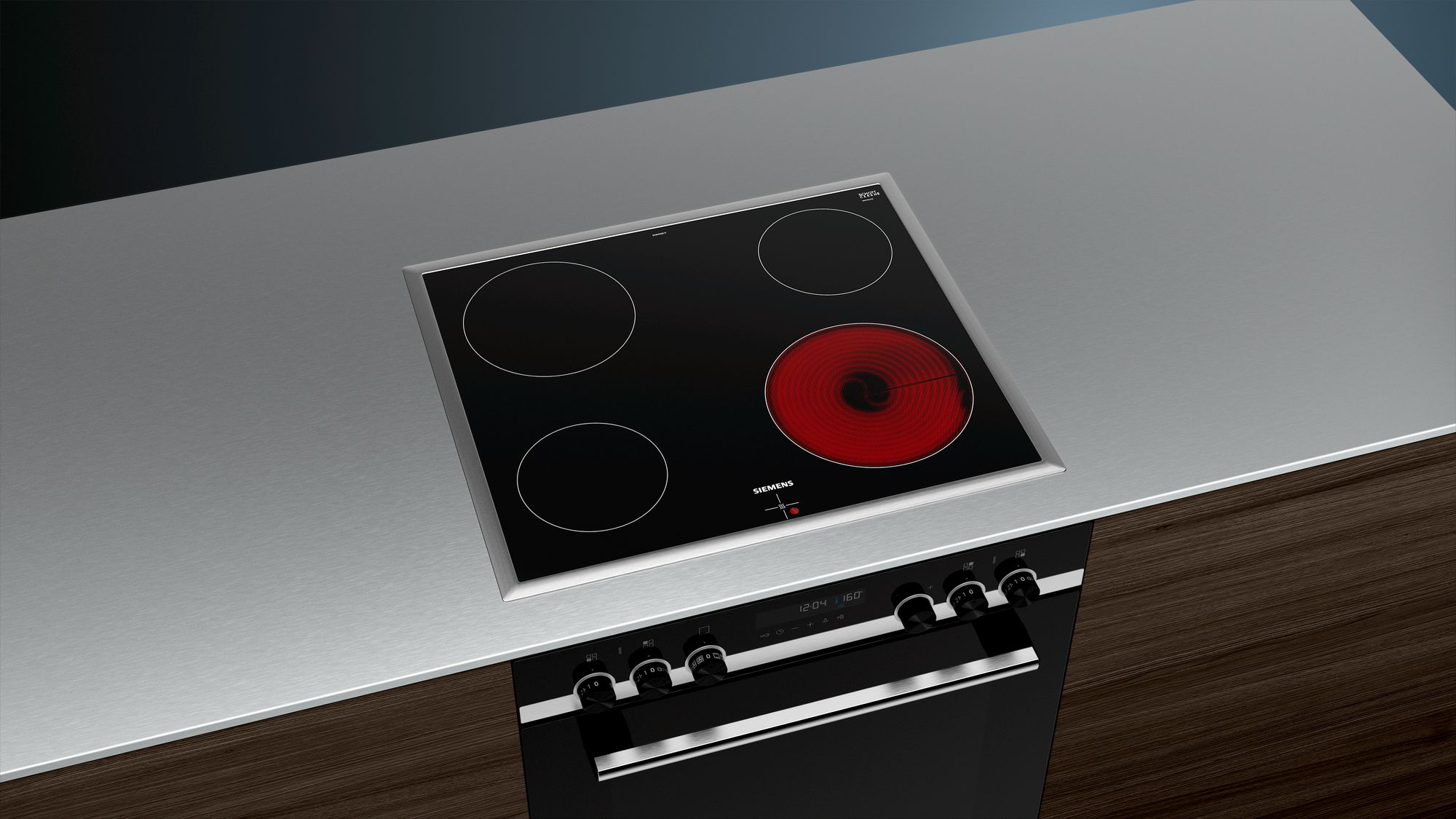 Une table de cuisson électrique encastrée avec quatre brûleurs noirs et un cadre argenté.