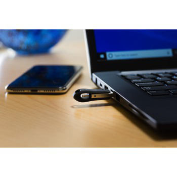 Schwarzer Laptop mit eingestecktem USB-Stick und Mobiltelefon auf einem Holztisch.