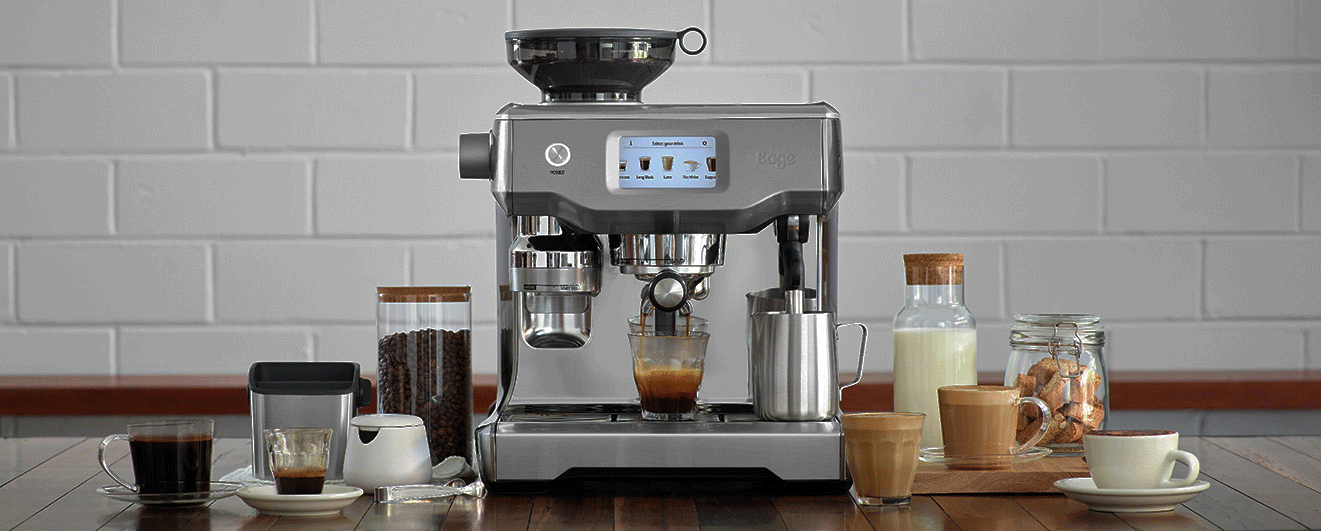 Une machine à expresso prépare du café. Des tasses, du lait et des biscuits sont sur une table en bois. Un mur de briques blanches en arrière-plan.