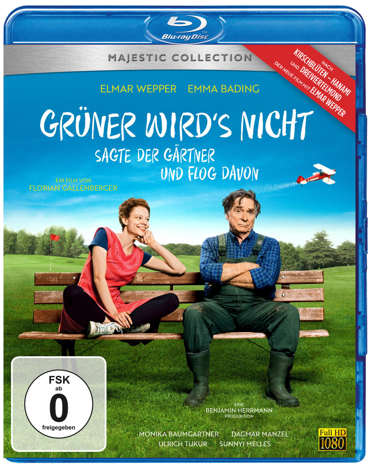 Filmcover. Zwei Personen sitzen auf einer Bank in einem Garten. Text: Grüner wird's nicht und ein Flugzeug.
