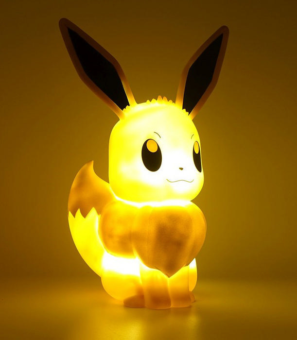 Eevee Pokémon Lampe. Gelbes Licht, das von der Figur ausgeht. Ohren und Schwanz sind sichtbar.