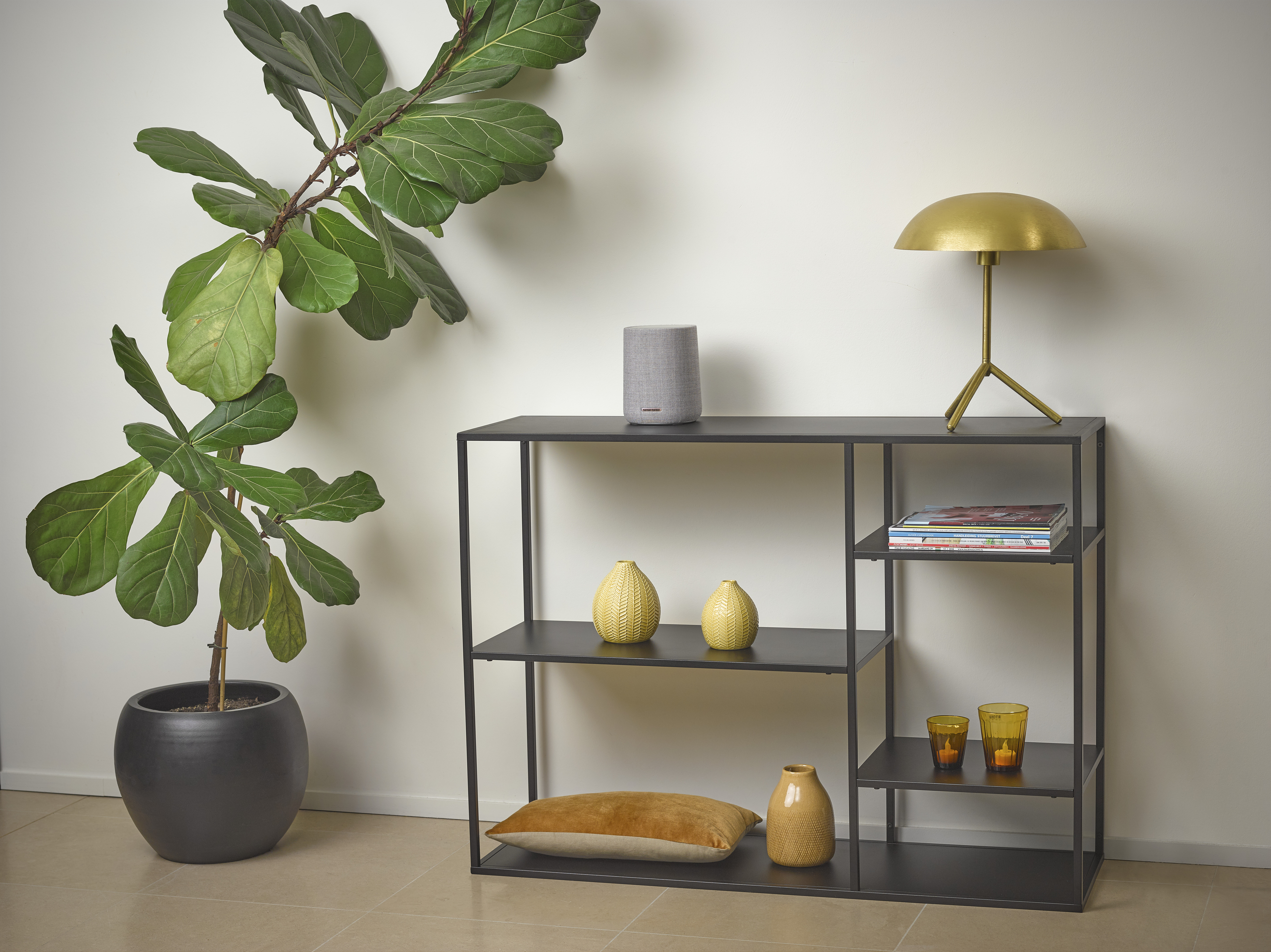 Moderne woonkamer met plant, plank, tafellamp en decoraties. Neutraal kleurenschema.
