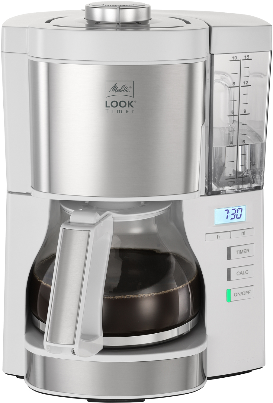 Cafetière argent et blanche. Carafe en verre avec du café. L'affichage numérique indique 7h30.