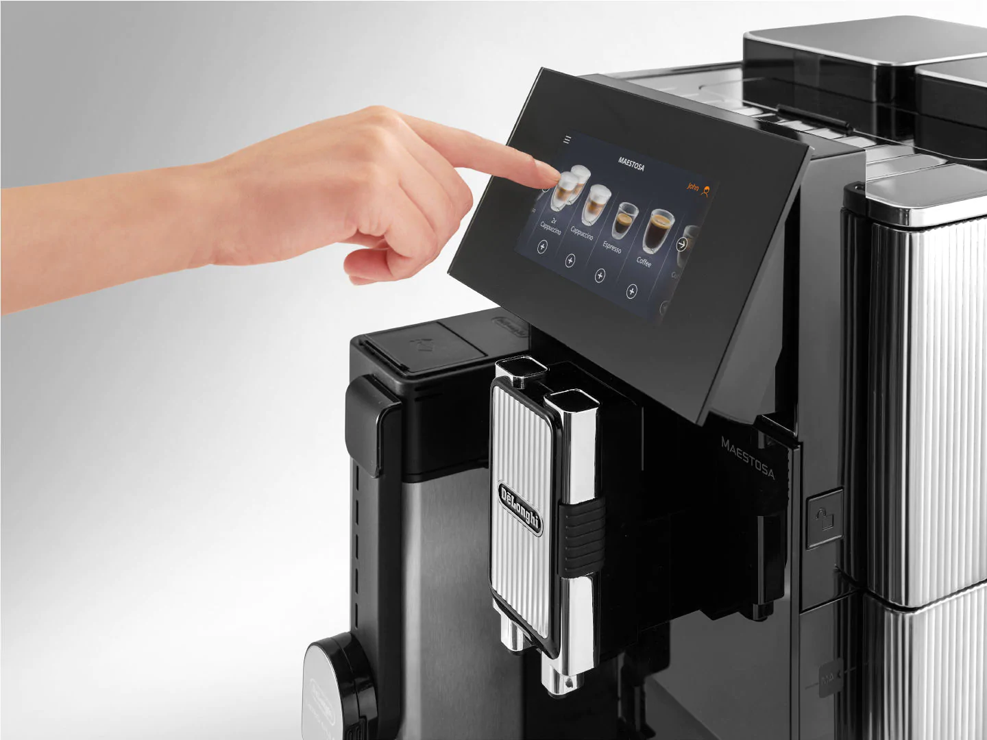 La main d'une personne touche un écran tactile sur une machine à café noire.