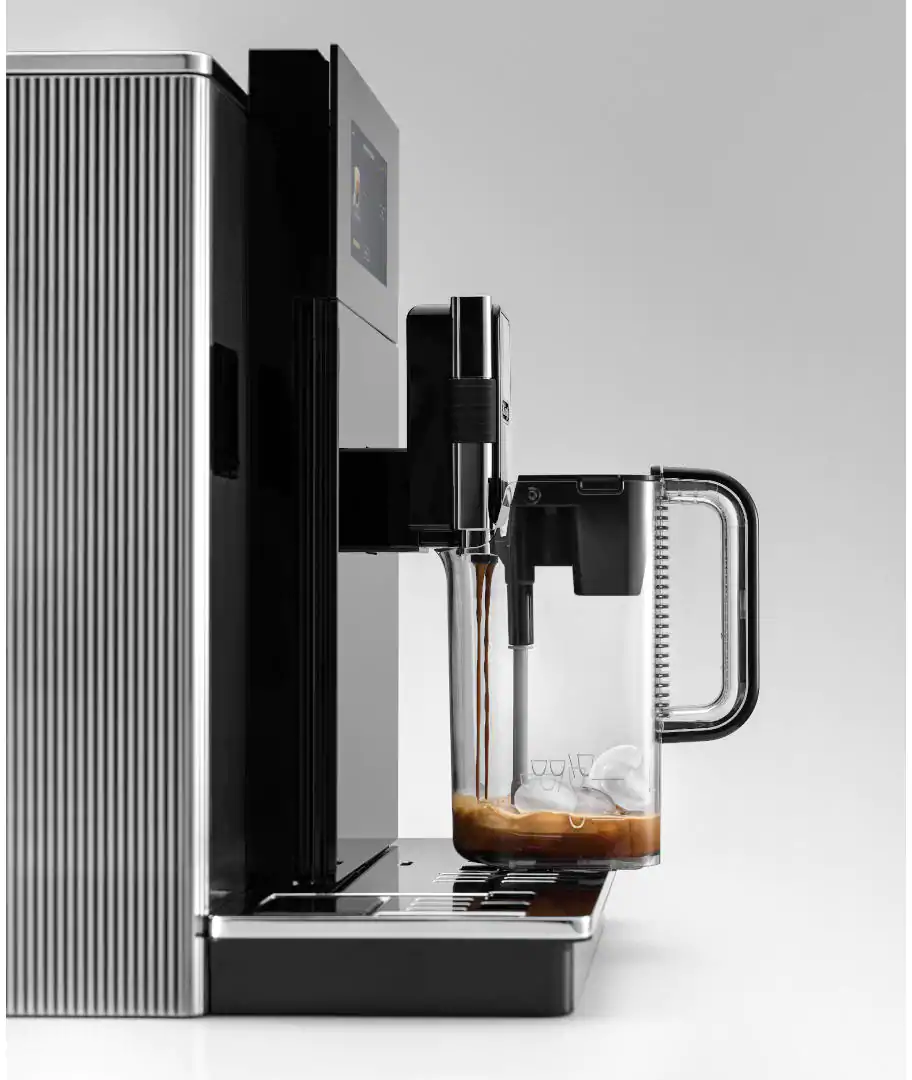Machine à café distribuant du café dans un verre avec des glaçons. Design noir et argent, fond blanc.