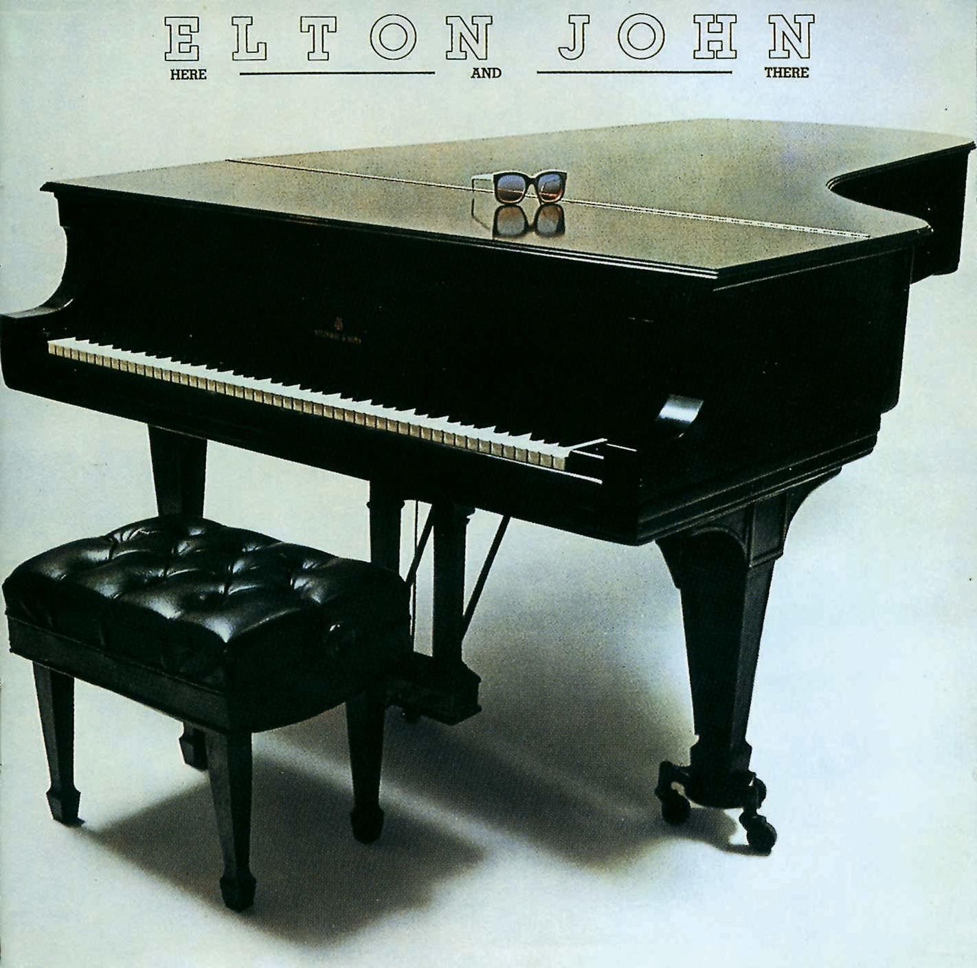 Elton John album borító, fekete zongora, zsámoly, szemüveg a zongorán. Cím: Here and There. Fekete-fehér.