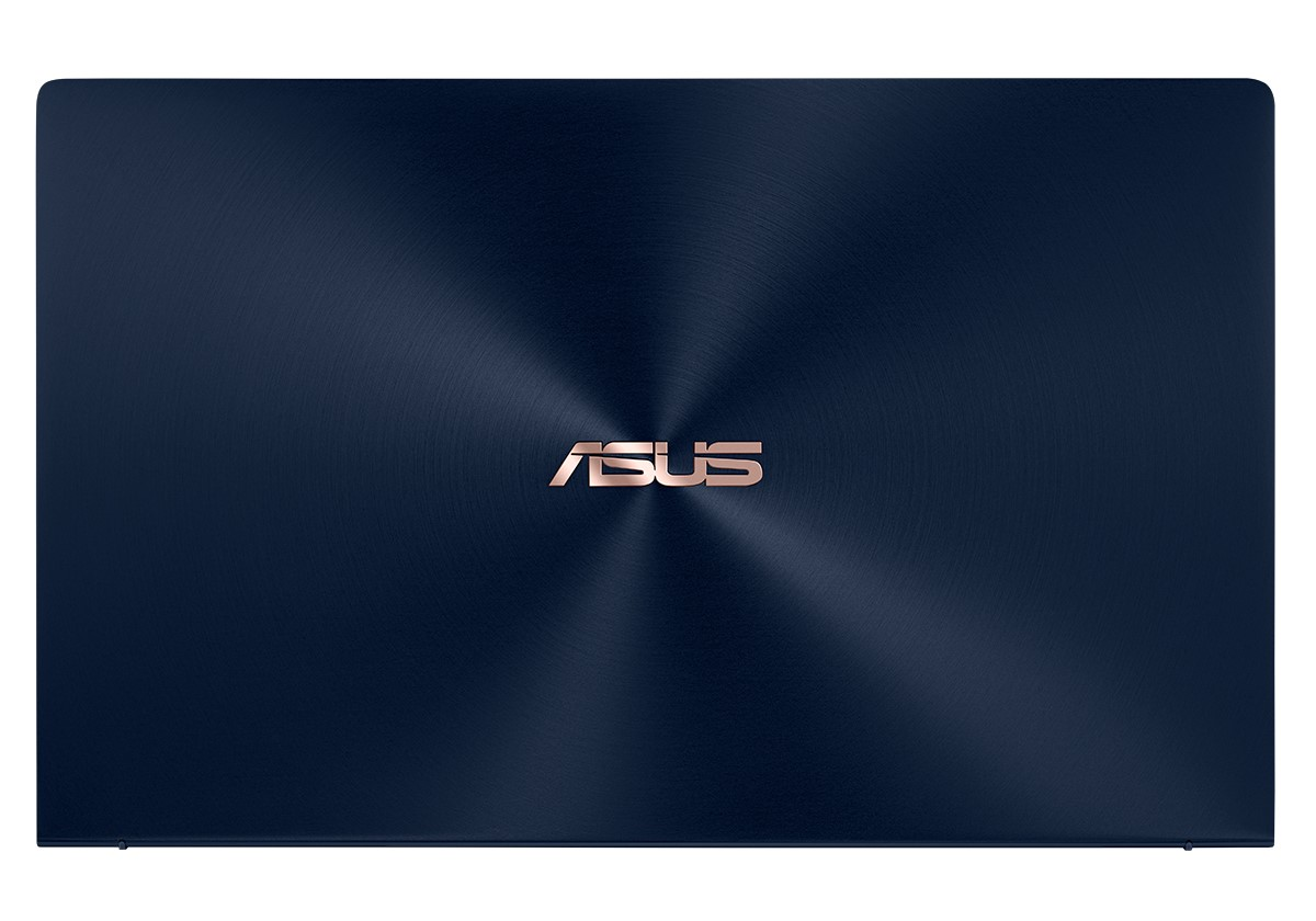 Tapa de portátil azul oscuro con el logo ASUS en dorado. La superficie tiene patrones circulares concéntricos.