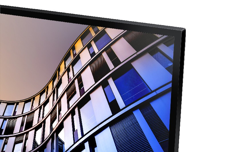 Primer plano de un monitor de computadora. La pantalla muestra un edificio curvo con ventanas azules y blancas.