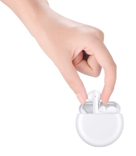 Mano sosteniendo auriculares inalámbricos blancos dentro de un estuche blanco.