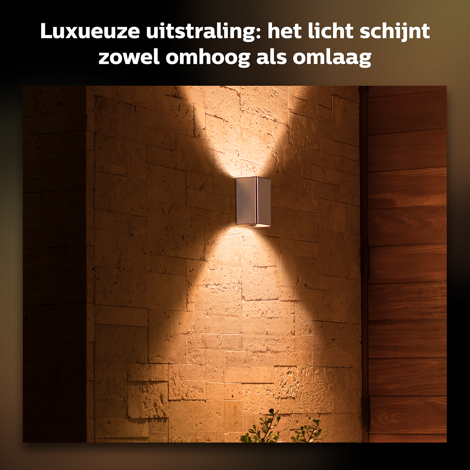 Outdoor wall lamp, shining light upwards and downwards on a stone wall.