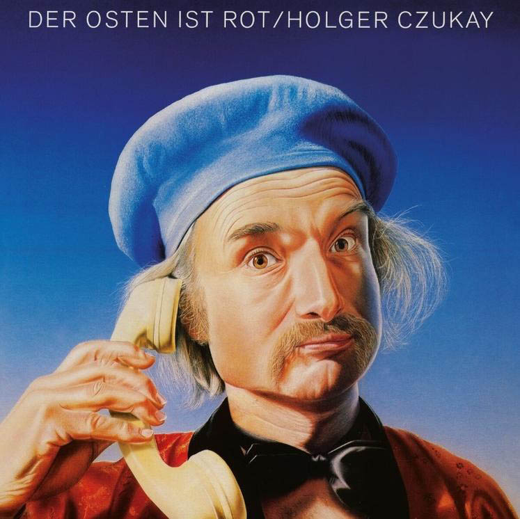 Porträt eines Mannes mit blauem Hut und Telefonhörer. Er trägt eine rote Jacke und eine schwarze Fliege. Blauer Hintergrund.