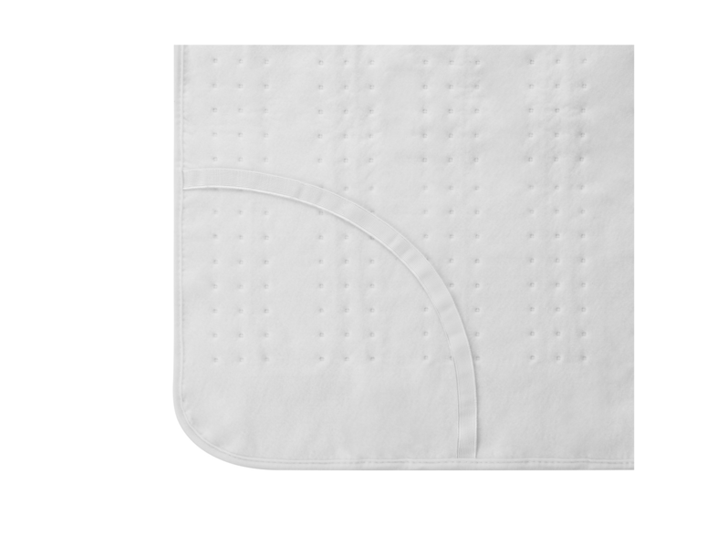 Primer plano de protector de colchón acolchado blanco. Costura curva en la esquina inferior derecha.