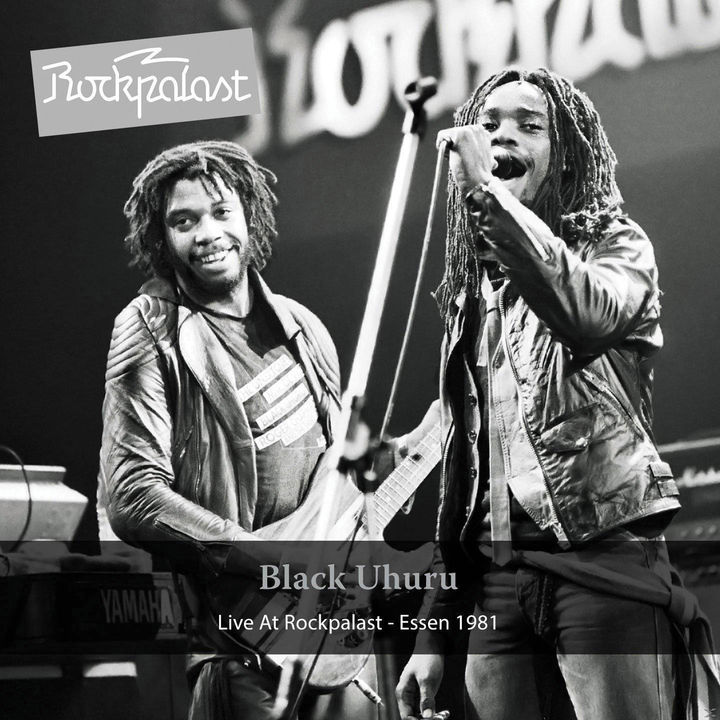 Live-Konzertfoto von Black Uhuru, zwei Männer performen auf der Bühne, mit Band, in Schwarzweiß.