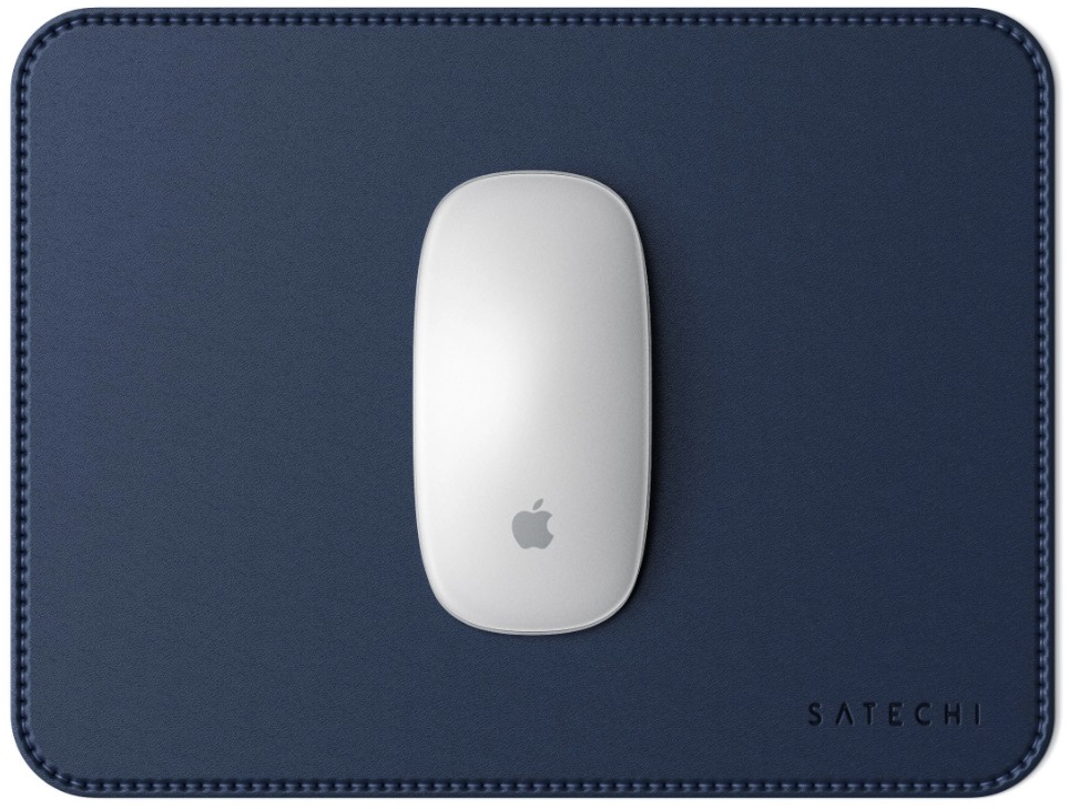 Une souris Apple blanche sur un tapis de souris en cuir bleu foncé. Le tapis a des bords cousus.