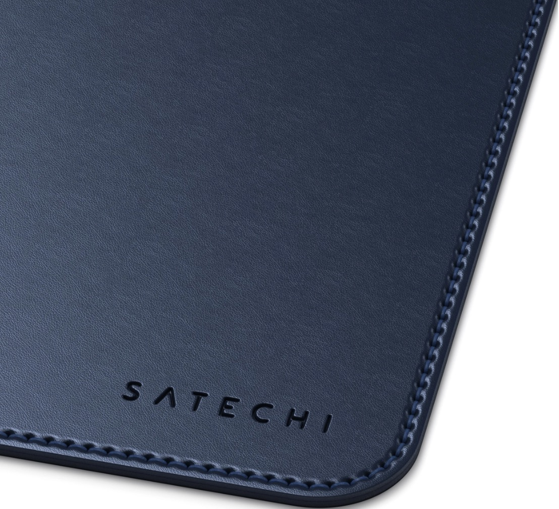 Gros plan d'un tapis de bureau en cuir bleu avec le mot 'Satechi' imprimé.