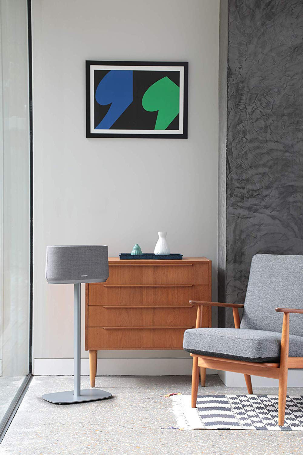 Moderne woonkamer met een luidspreker op een standaard, een dressoir en een schilderij.