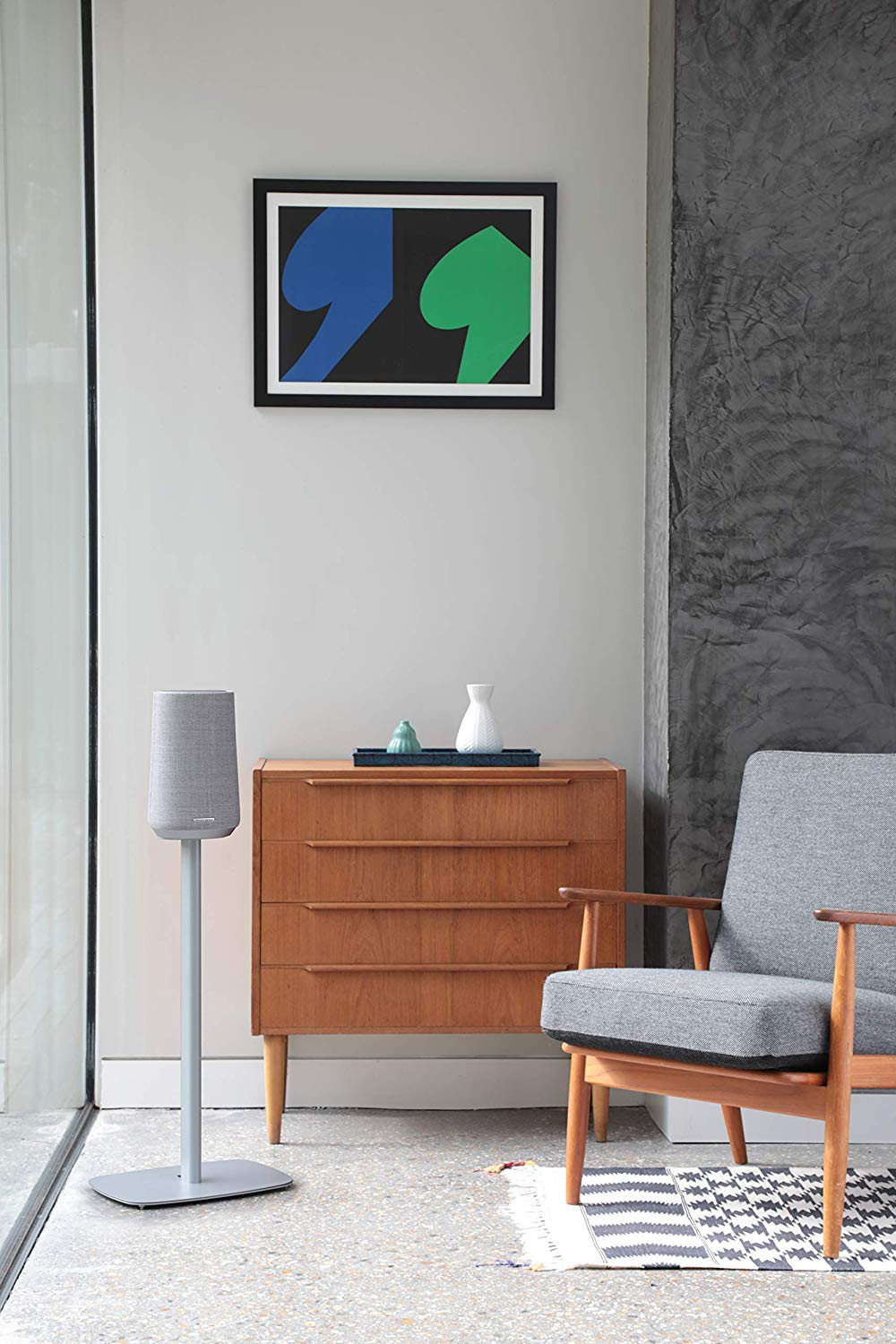 Interieur met luidspreker, kast, kunst en een stoel.