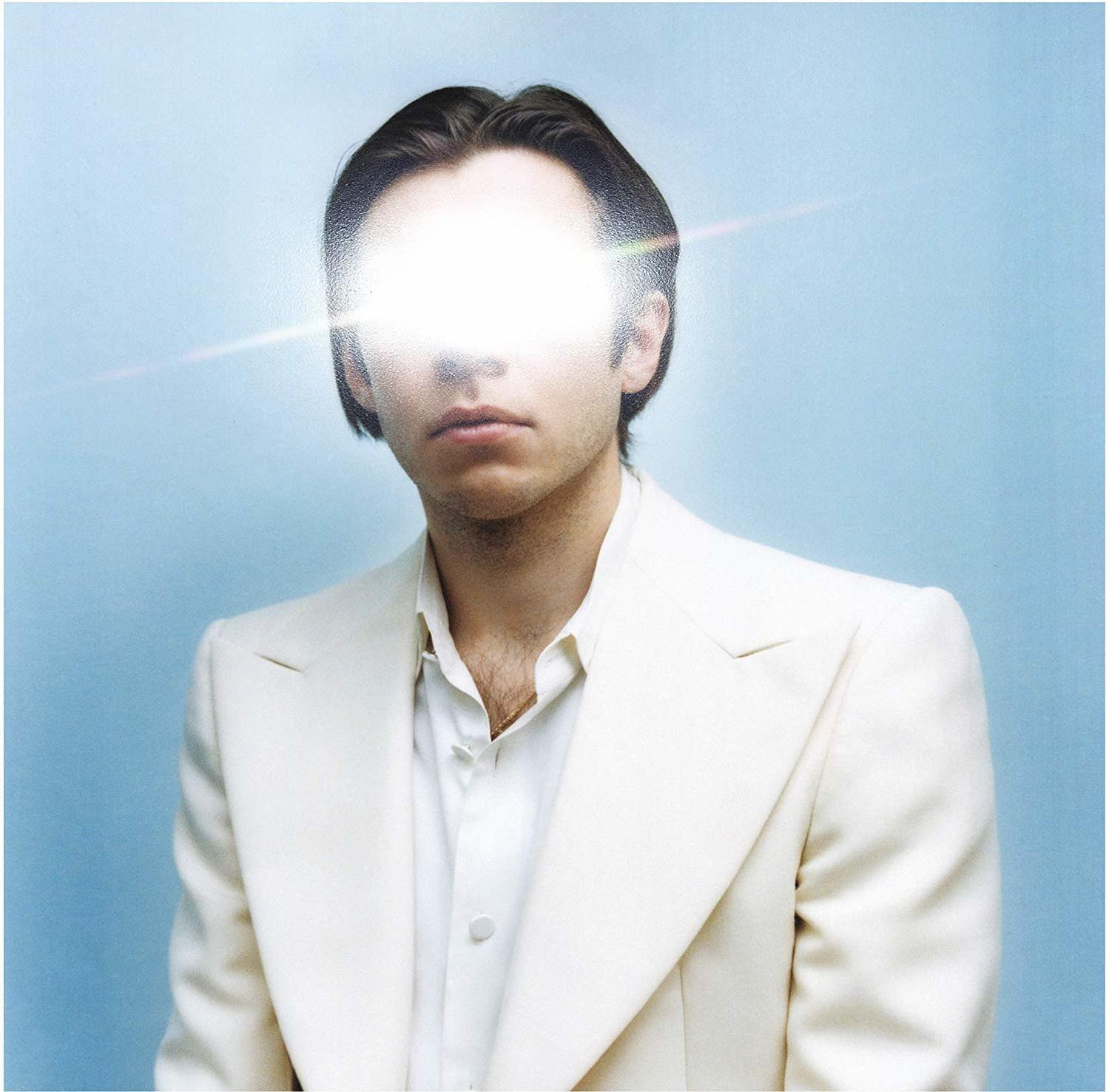Albumhoes: Een persoon met een helder licht dat hun gezicht bedekt, draagt een wit pak.