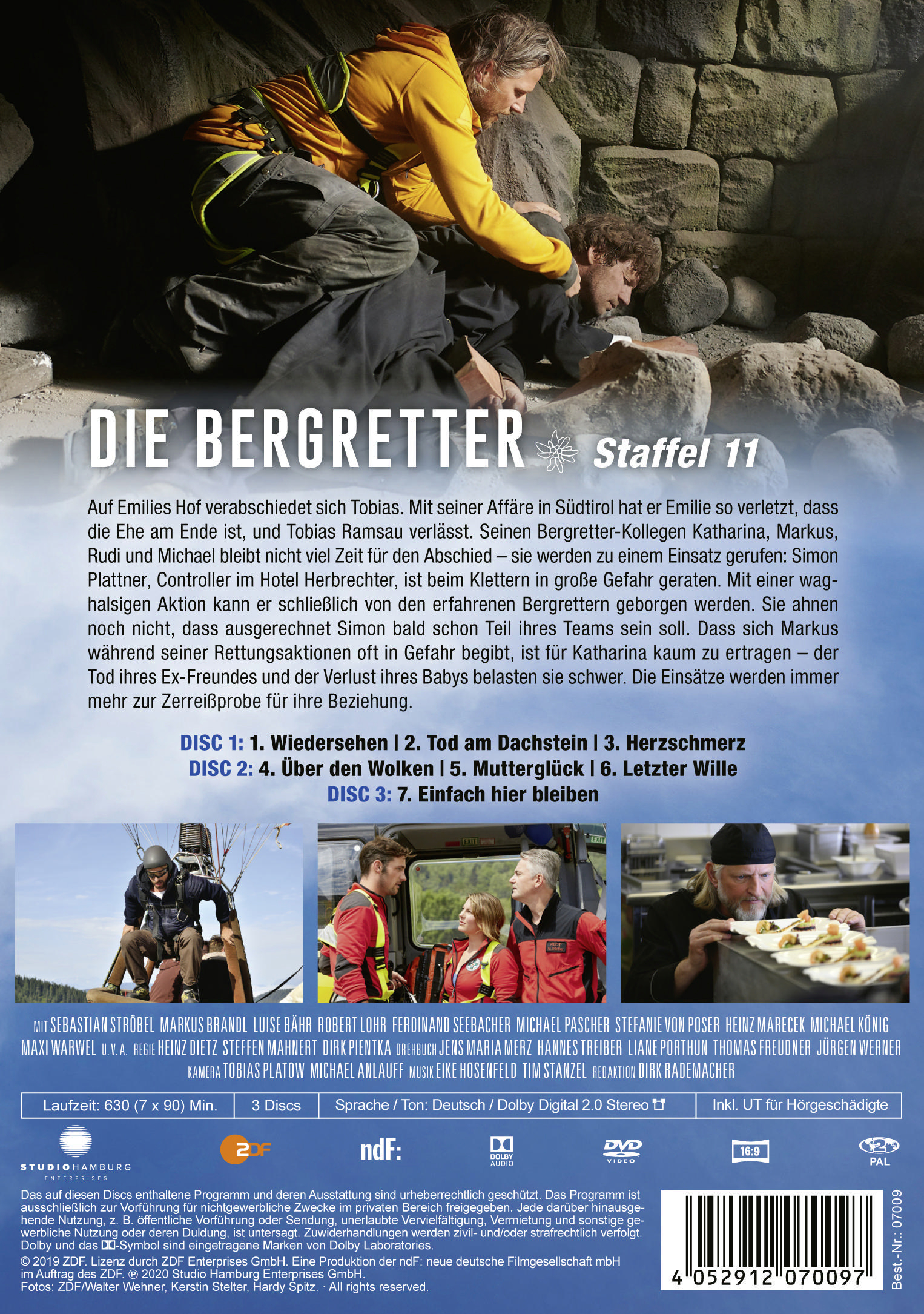 Ein DVD-Cover mit einer Filmszene. Zwei Männer helfen einem anderen. Berge sind abgebildet.