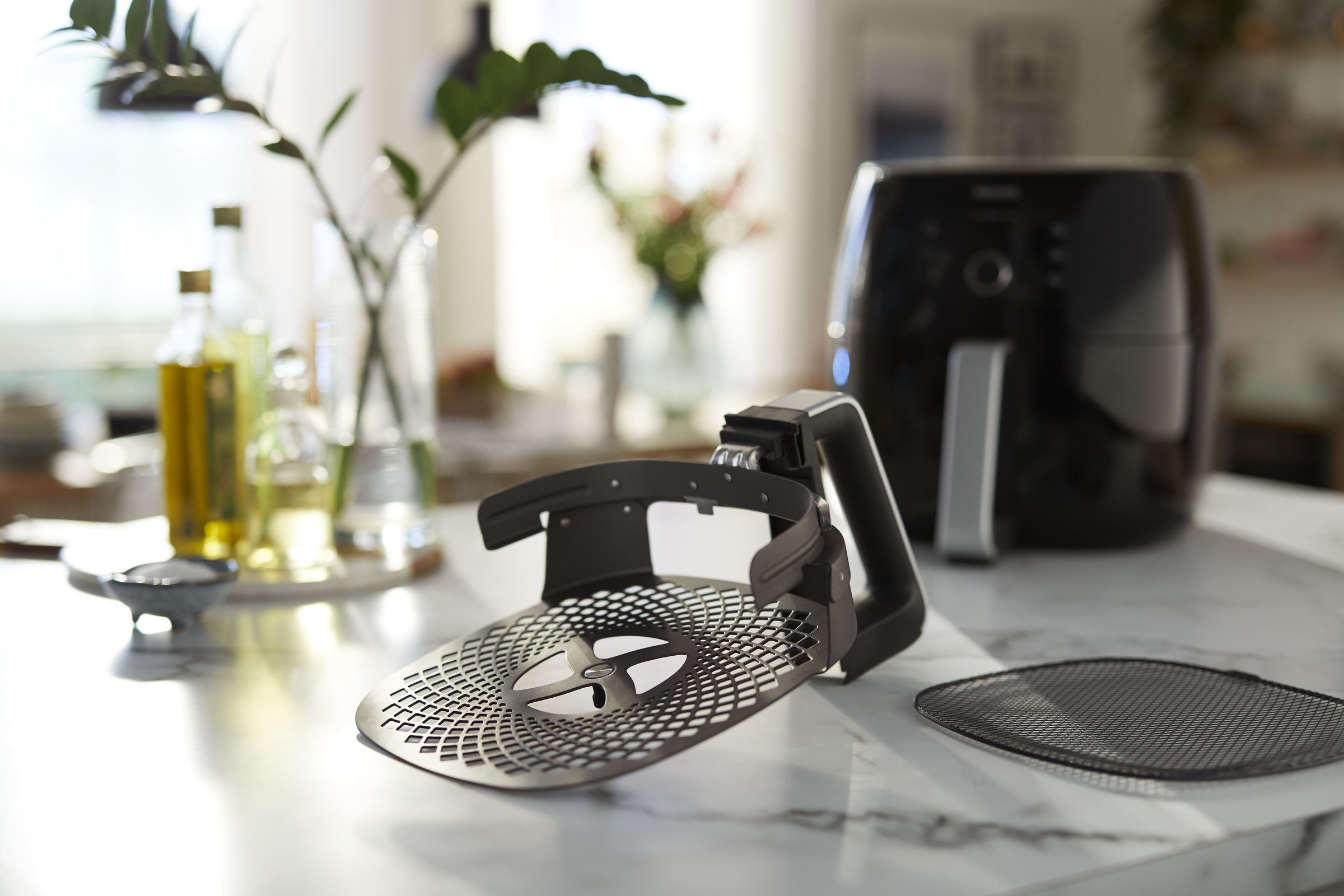 An air fryer with its basket removed, placed on a kitchen countertop.