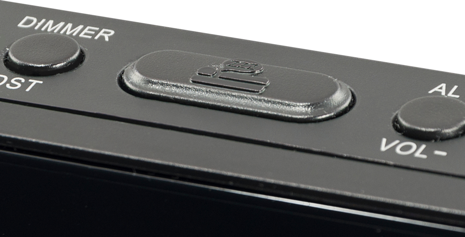 Close-up of a black alarm clock with buttons, including a snooze button.