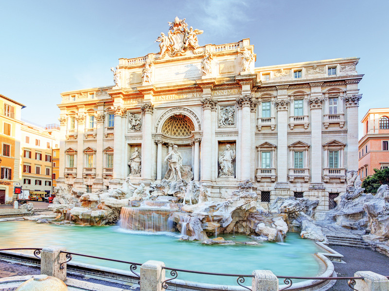 La Fontana di Trevi a Roma, Italia, con acqua che scorre e cielo blu.