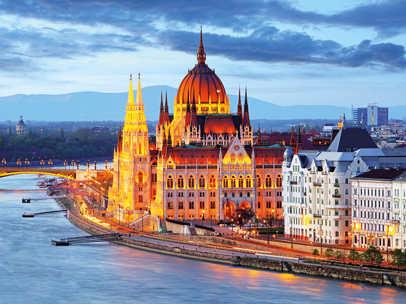 Budapest, Ungheria, al crepuscolo: edificio del Parlamento, fiume, luci della città e cielo nuvoloso.