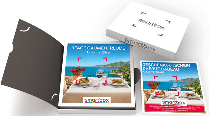 Set confezione regalo Smartbox: scatola, cartella aperta e due biglietti con vista cibo e spiaggia.