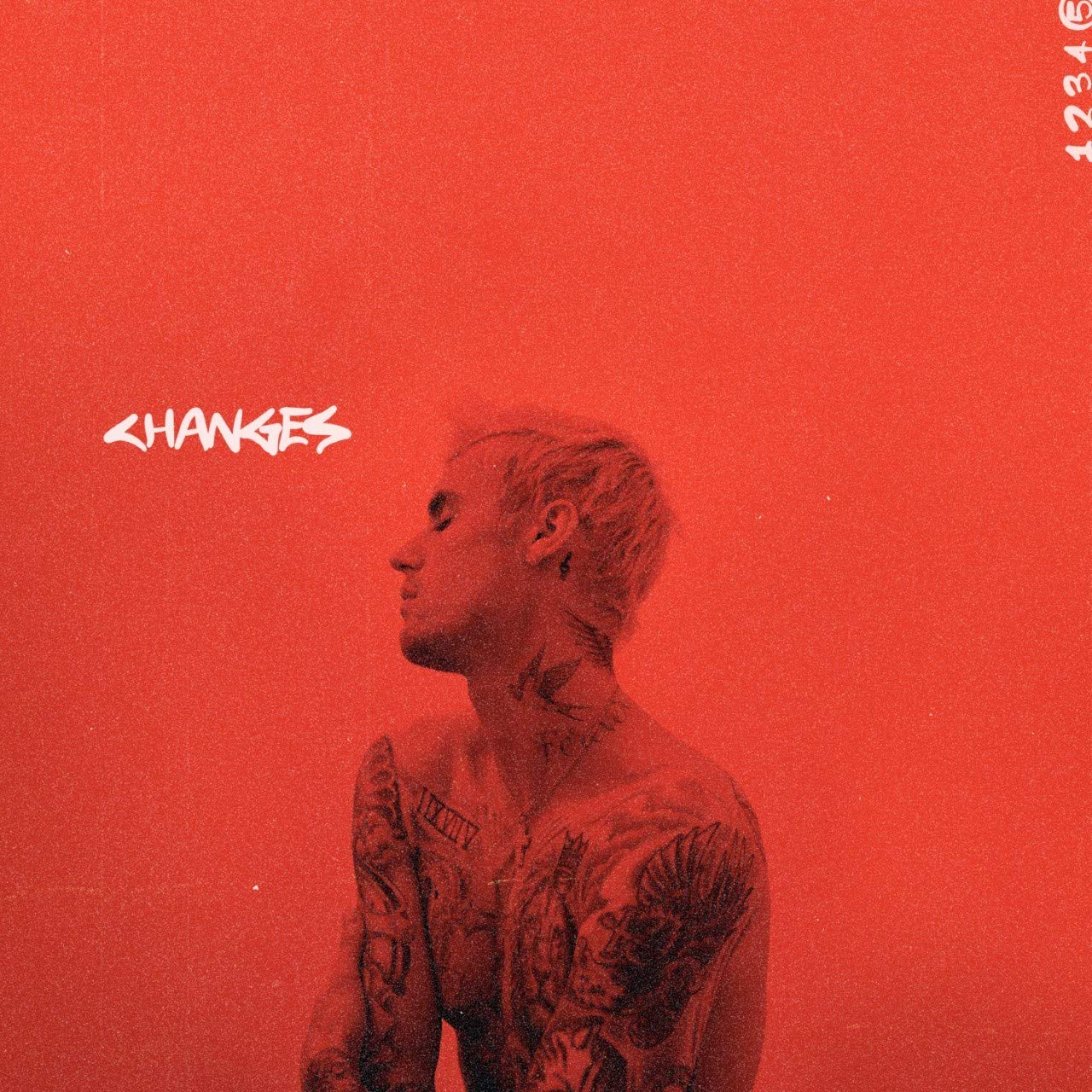 Album borító: Justin Bieber tetoválásokkal, lefelé néz, piros háttéren. A 'Changes' szó látható.