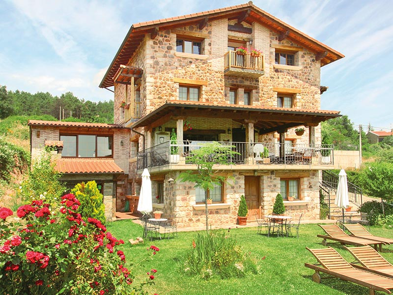 Una casa in pietra con giardino, piscina e una bellissima vista.