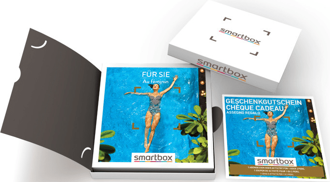 Confezioni regalo Smartbox con buoni regalo con una donna in costume da bagno nell'acqua, con testo in francese e tedesco.