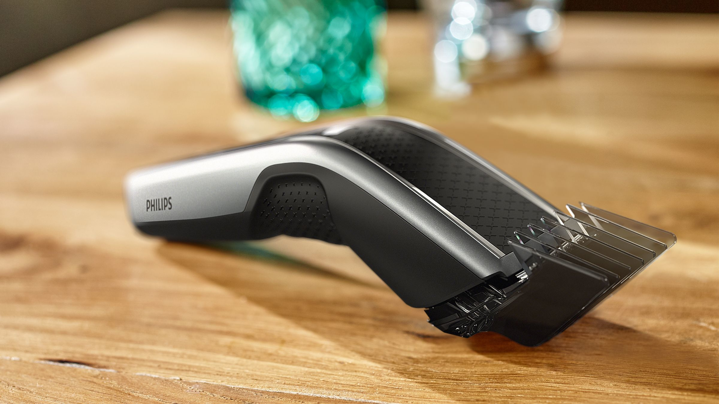 A black and silver Philips hair clipper sitting on a wooden table.