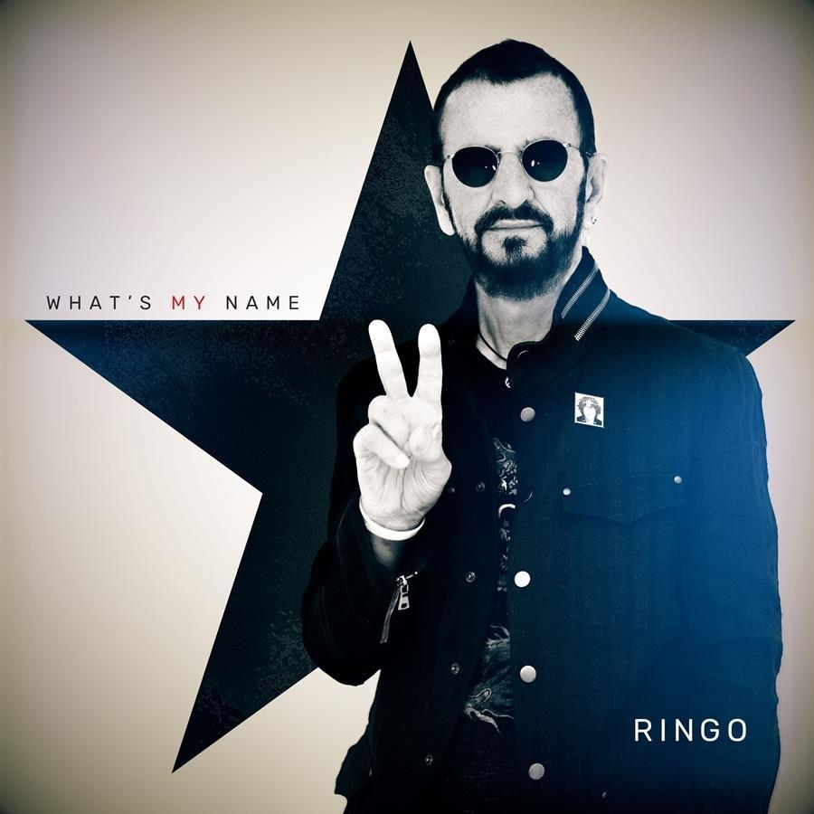 Ringo Starr fekete kabátban, békés jelet mutat, csillaggal a háttérben.