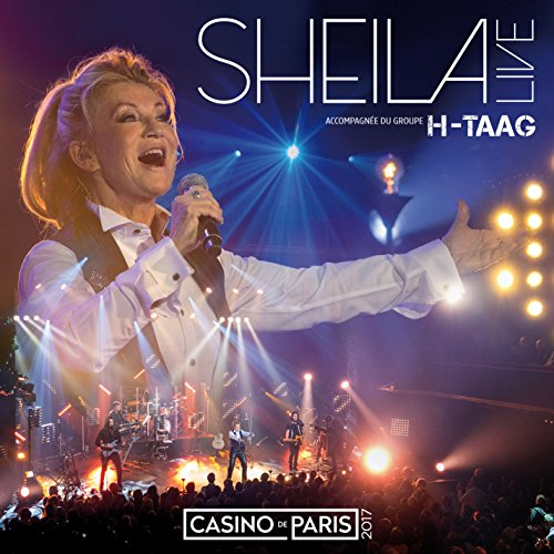 Sheila sur scène chantant dans un micro, avec des lumières et un groupe. Le texte "SHEILA LIVE" est en haut.