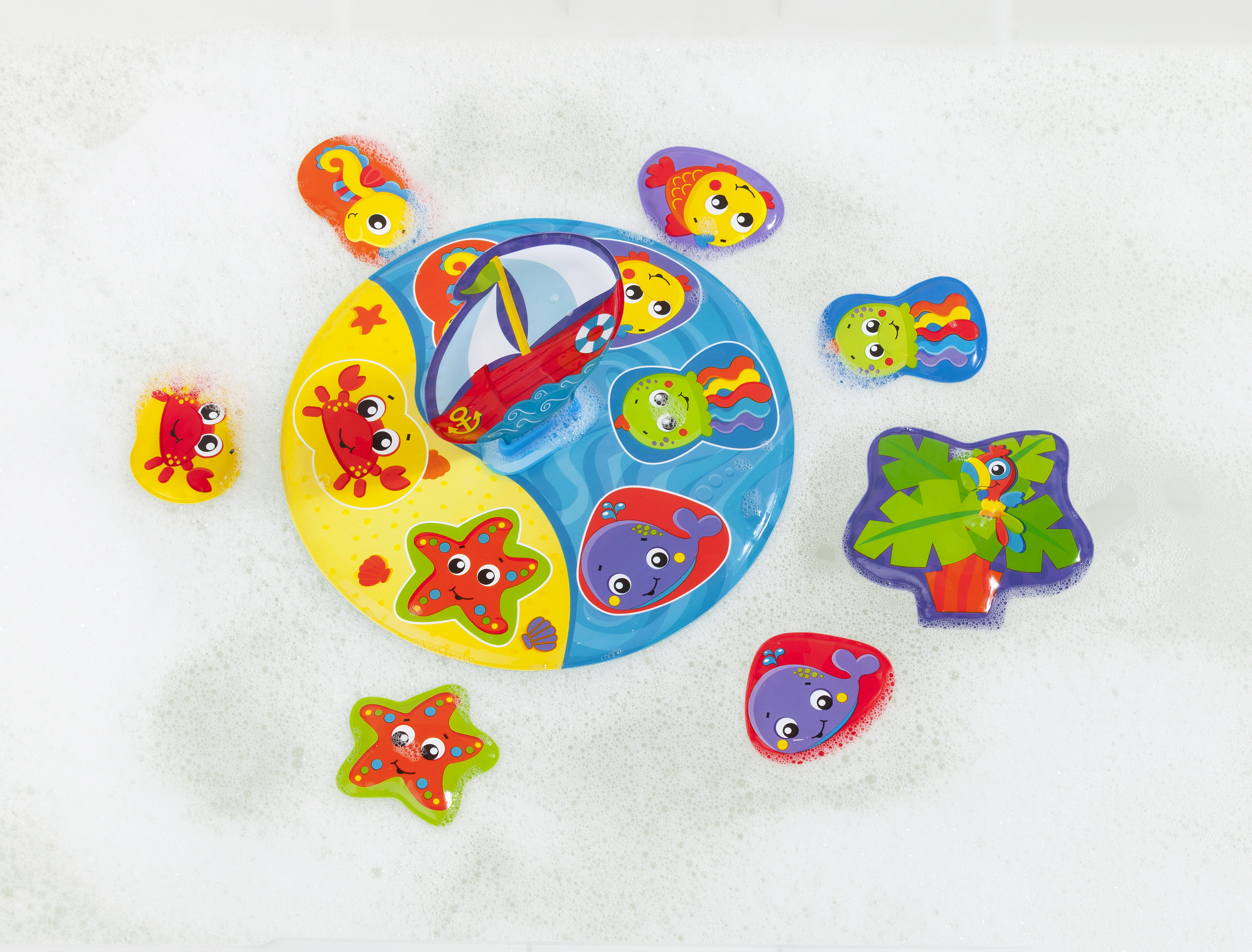 Buntes Badespielzeug in Seifenwasser. Enthält Boot, Fisch, Seestern und Oktopus.