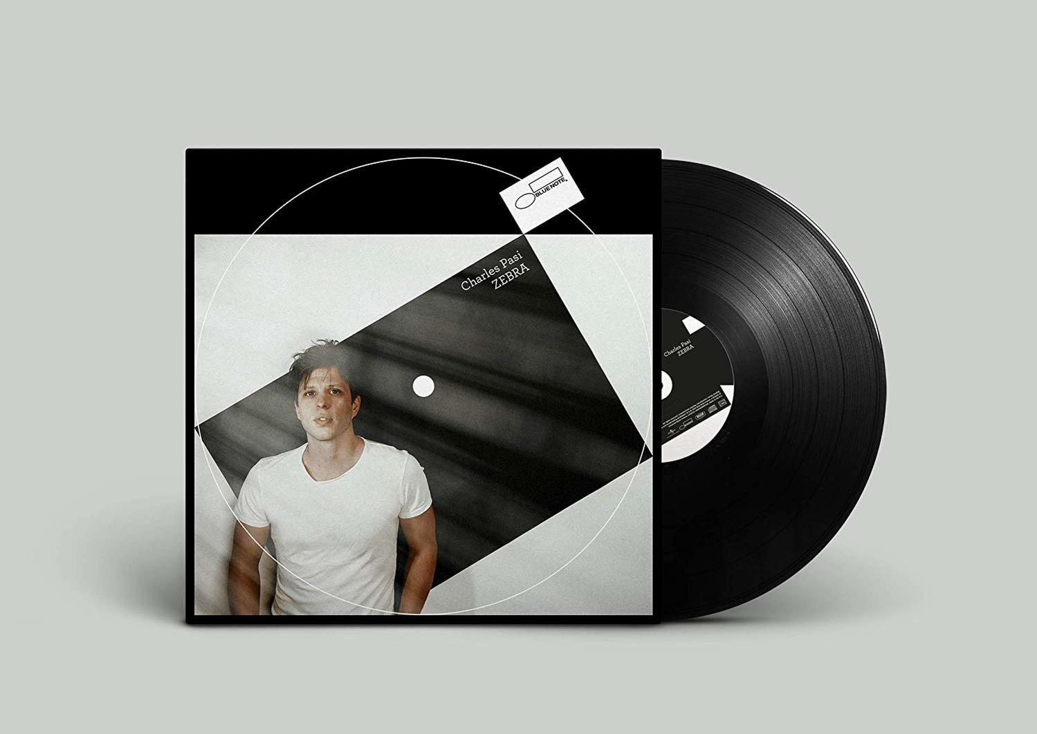 Albumcover: Ein Mann in weißem Hemd. Schwarz-weißes geometrisches Design mit einer Schallplatte.